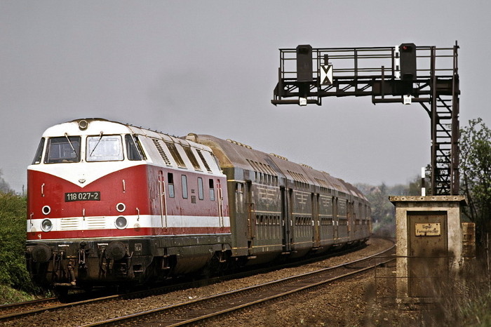 Signalausleger mit 2 Lichtsignalen, darunter Lok BR 118 mit Doppelstockzug